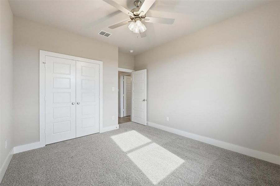 Unfurnished bedroom with carpet floors, ceiling fan, and a closet