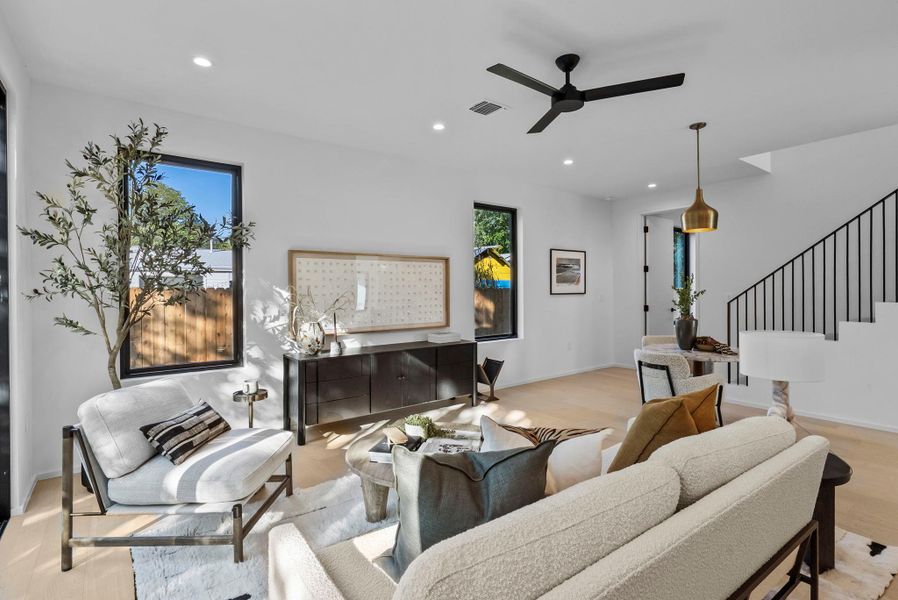 Living area with stairway, recessed lighting, light wood floors, and a ceiling fan Living area with stairway, recessed lighting, light wood floors, and a ceiling fan