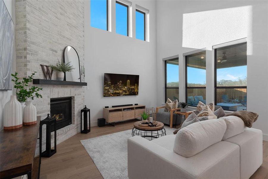 Living room featuring a high ceiling, a fireplace, and wood finished floors