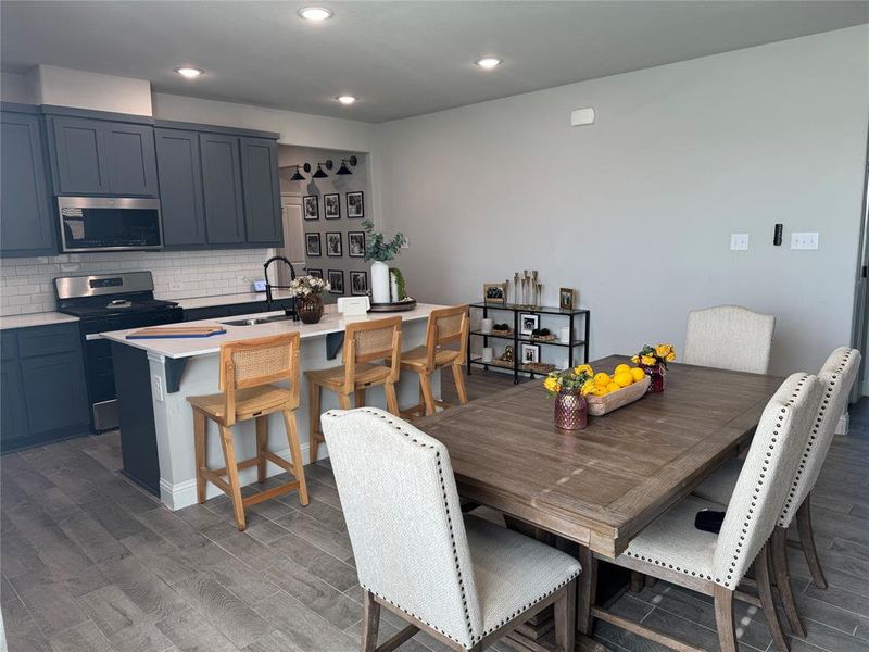 Dining area with dark wood-type flooring and recessed lighting Dining area with dark wood-type flooring and recessed lighting