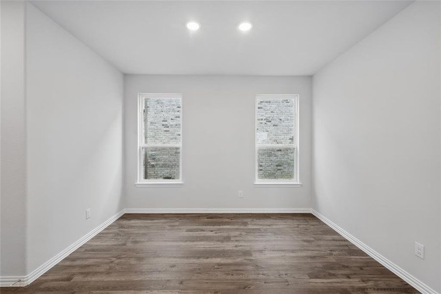Unfurnished room with dark wood-type flooring and healthy amount of natural light