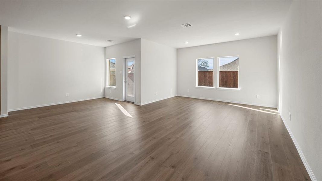 Empty room featuring dark wood-style flooring and recessed lighting