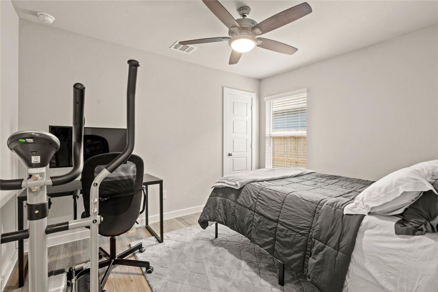 The secondary bedroom offers a comfortable and versatile space perfect for family, guests, or a home office. Featuring neutral tones, wood-look flooring, and abundant natural light, this room feels bright and inviting. A ceiling fan adds year-round comfort, while the functional layout easily accommodates bedroom furnishings or workspace needs. Conveniently located near the secondary bath, this room provides both comfort and flexibility.