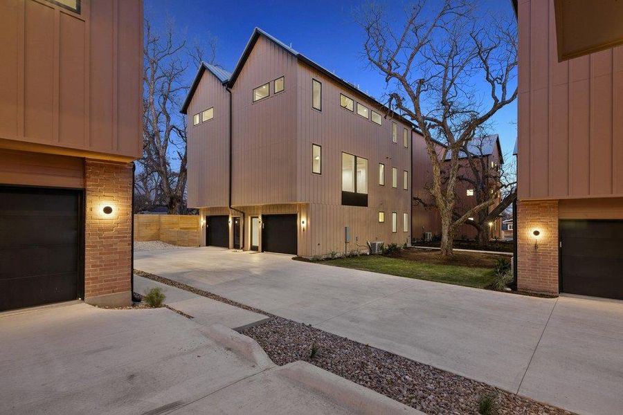 View of side of property featuring a garage, brick siding, and concrete driveway