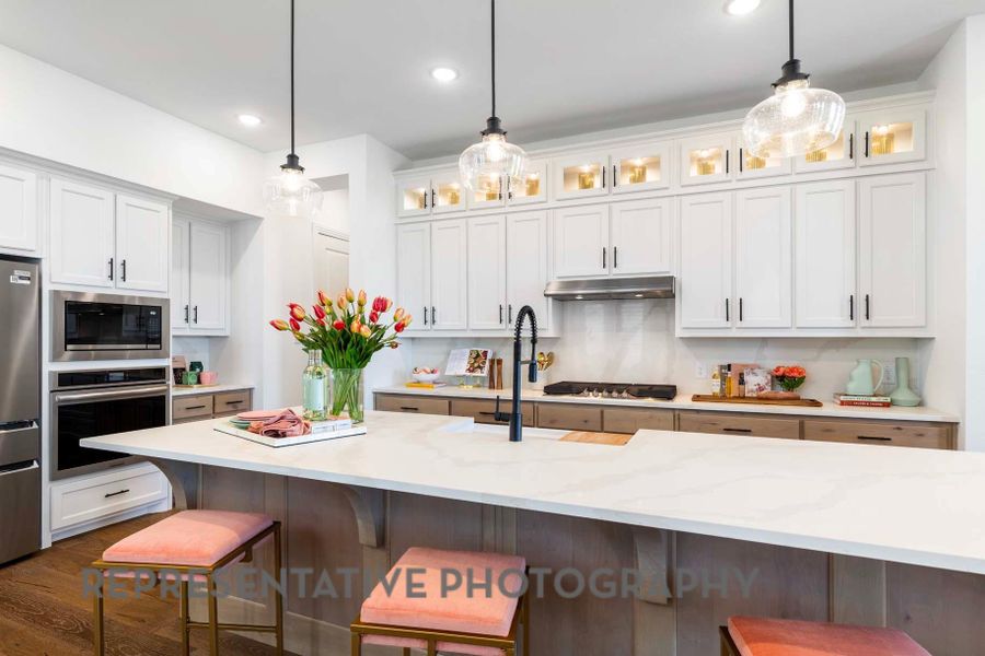 Kitchen with a breakfast bar area, appliances with stainless steel finishes, under cabinet range hood, and pendant lighting Kitchen with a breakfast bar area, appliances with stainless steel finishes, under cabinet range hood, and pendant lighting