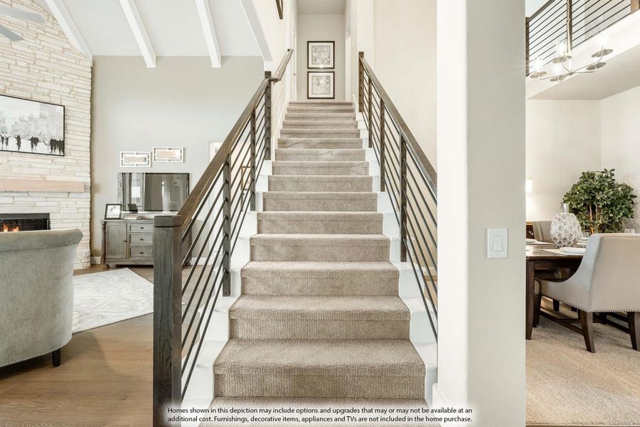 Carpeted staircase with metal railing leading to upper floor, with living room and dining area visible on each side.