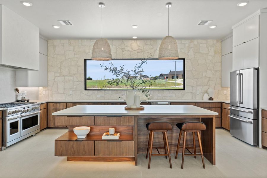 Kitchen with modern cabinets, white cabinetry, decorative light fixtures, high end appliances, and recessed lighting