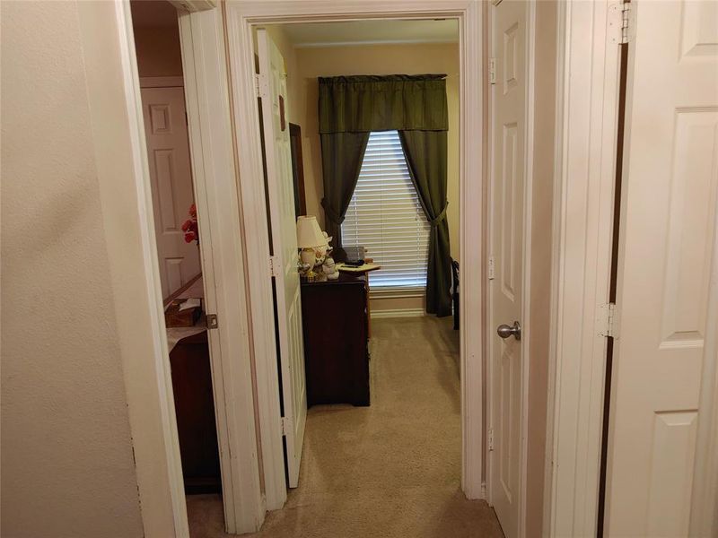Interior hallway featuring neutral wall paint and carpeted flooring