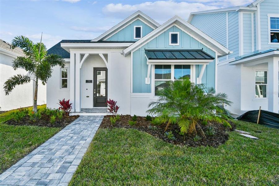 Front exterior of a new home in Emerald Landing at Waterside at Lakewood Ranch – Cottage Series, Sarasota, FL, highlighting curb appeal (Image 1). Front exterior of a new home in Emerald Landing at Waterside at Lakewood Ranch – Cottage Series, Sarasota, FL, highlighting curb appeal (Image 1).