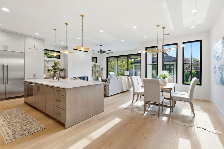Kitchen featuring modern cabinets, pendant lighting, stainless steel appliances, light wood-style floors, and recessed lighting
