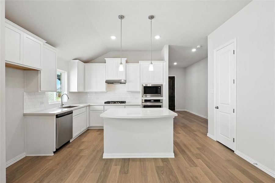 Kitchen with lofted ceiling, a center island, white cabinetry, recessed lighting, and decorative backsplash