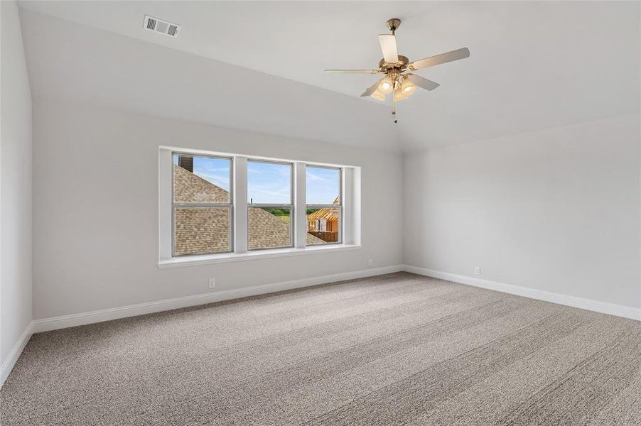 Spare room with light colored carpet, vaulted ceiling, and ceiling fan