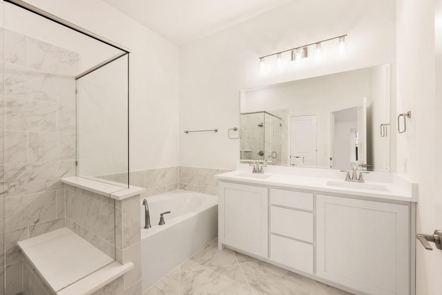 Master bathroom with double vanity, soaking tub, walk-in shower, and marble tile floors Master bathroom with double vanity, soaking tub, walk-in shower, and marble tile floors