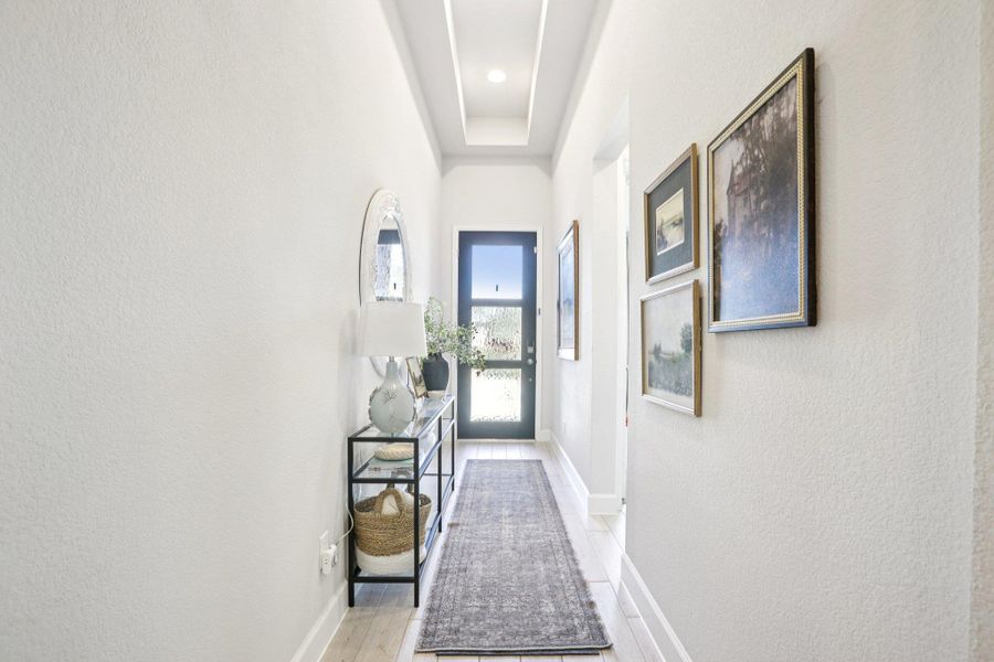Doorway with a textured wall and baseboards