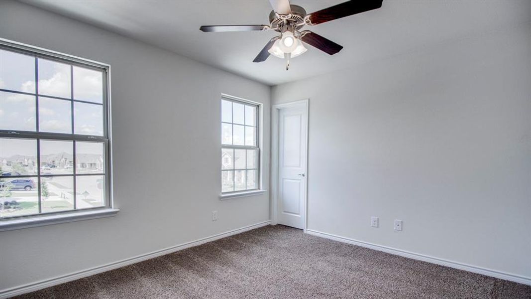 Carpeted empty room featuring baseboards and ceiling fan Carpeted empty room featuring baseboards and ceiling fan