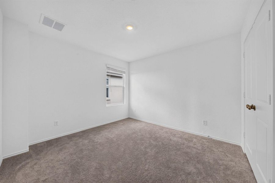 A well-lit bedroom provides a cozy retreat, featuring plush carpet and a clean, neutral palette. A well-lit bedroom provides a cozy retreat, featuring plush carpet and a clean, neutral palette.