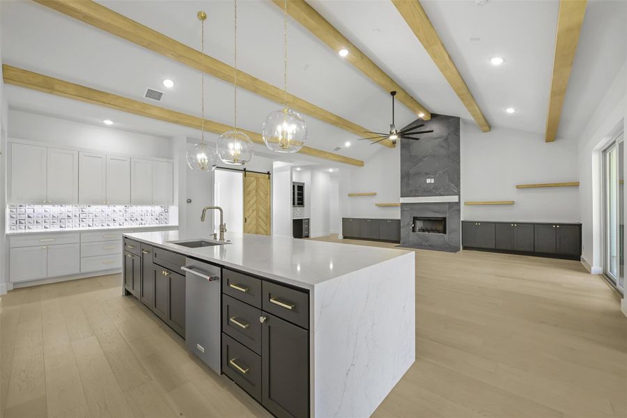 Kitchen with light wood-style floors, a fireplace, backsplash, pendant lighting, and recessed lighting
