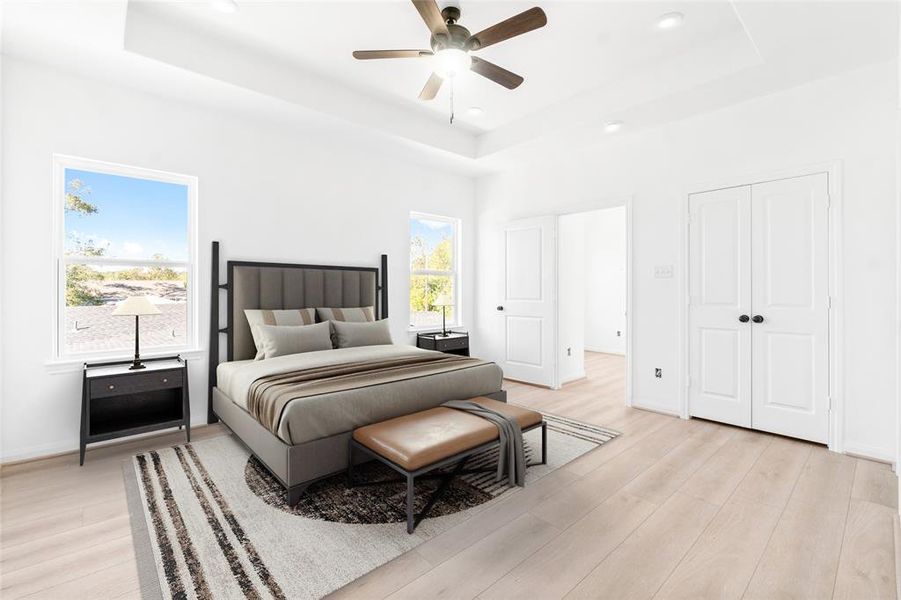 The master bedroom offers elegance and comfort, featuring two large windows, a tray ceiling, two closets, and a sleek ceiling fan. (Photo may be enhanced and may include virtual staging)