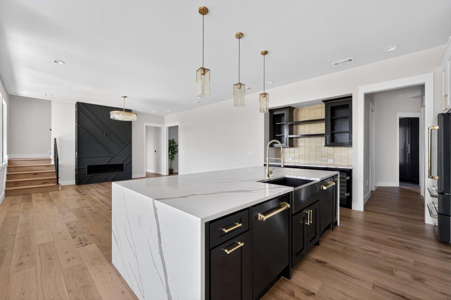 Gleaming stone countertops and warm hardwood floors anchor this open culinary and living space.