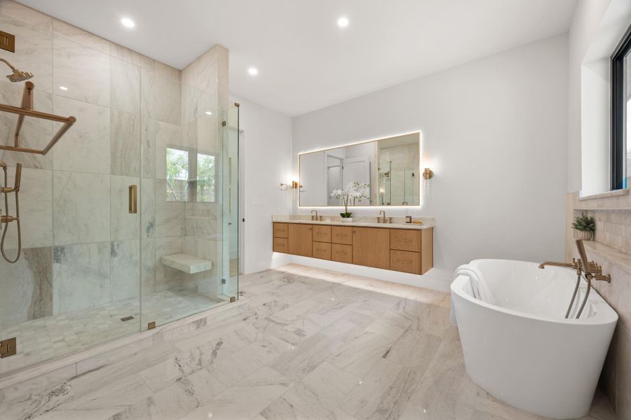 Polished stone flooring and a freestanding tub define this luxurious master bath retreat.