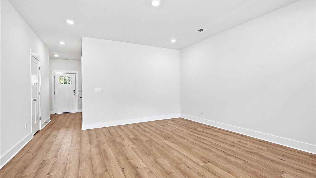 Spacious family room with rich hardwood flooring and elegant trim work in a reputable DRB Homes build