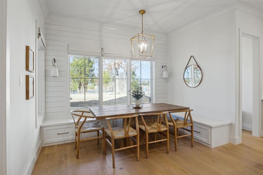 Dining space featuring baseboards, light wood-style flooring, breakfast area, crown molding, and a chandelier Dining space featuring baseboards, light wood-style flooring, breakfast area, crown molding, and a chandelier