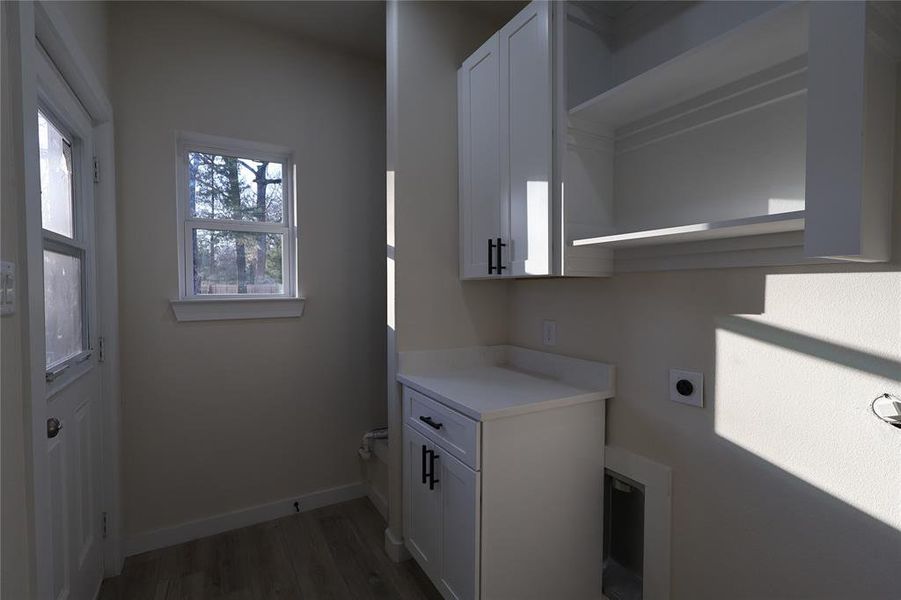 Laundry room featuring cabinet space, hookup for an electric dryer, and light wood-style flooring