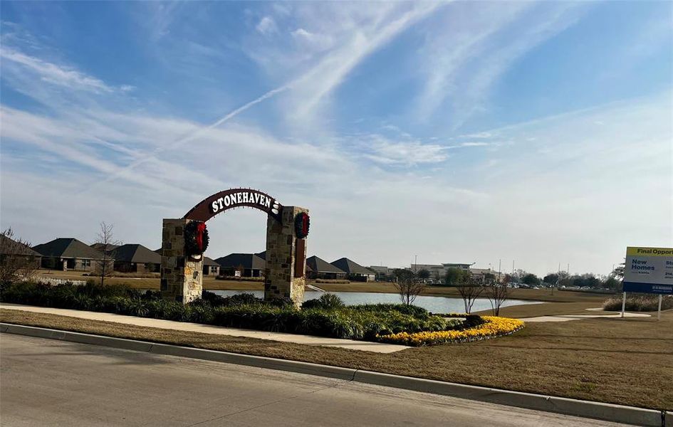 Community sign featuring a residential view and a water view