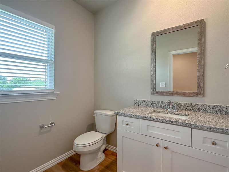 Bathroom with toilet, vanity, and hardwood / wood-style flooring