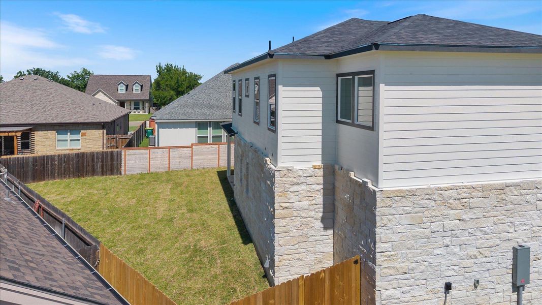 A well-maintained property with a spacious backyard and durable stone and siding construction.