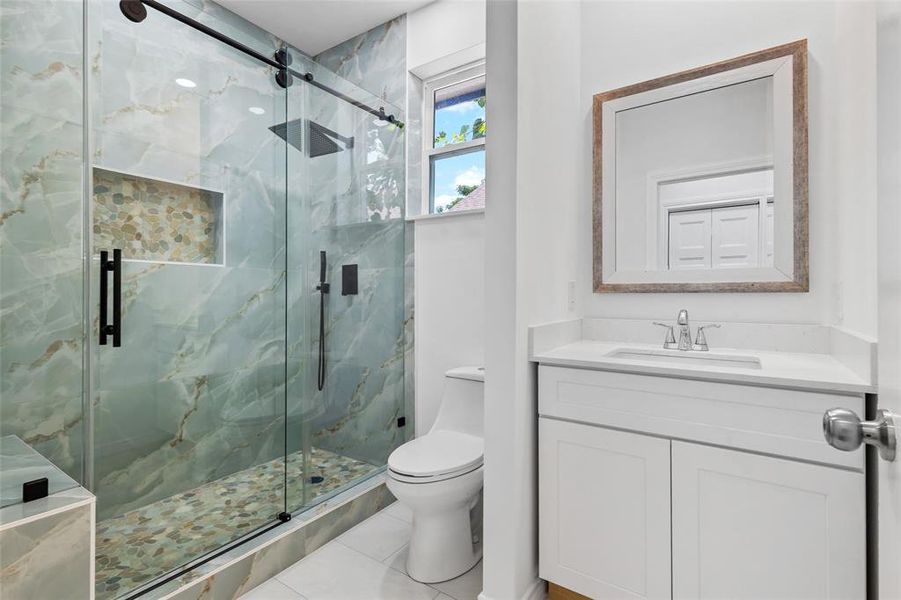 Second Bathroom with walking shower and beautiful tile and rain shower with a modern and calmed tile pattern and thick glass door window Second Bathroom with walking shower and beautiful tile and rain shower with a modern and calmed tile pattern and thick glass door window