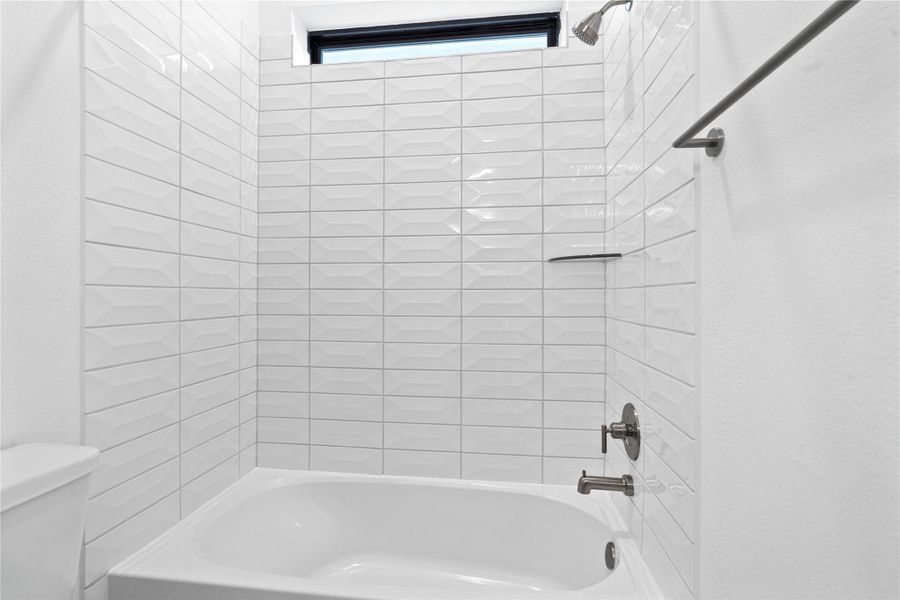 This modern bathroom features a clean white alcove bathtub paired with a sophisticated white subway tile surround that boasts a unique, elongated hexagonal pattern. This modern bathroom features a clean white alcove bathtub paired with a sophisticated white subway tile surround that boasts a unique, elongated hexagonal pattern.