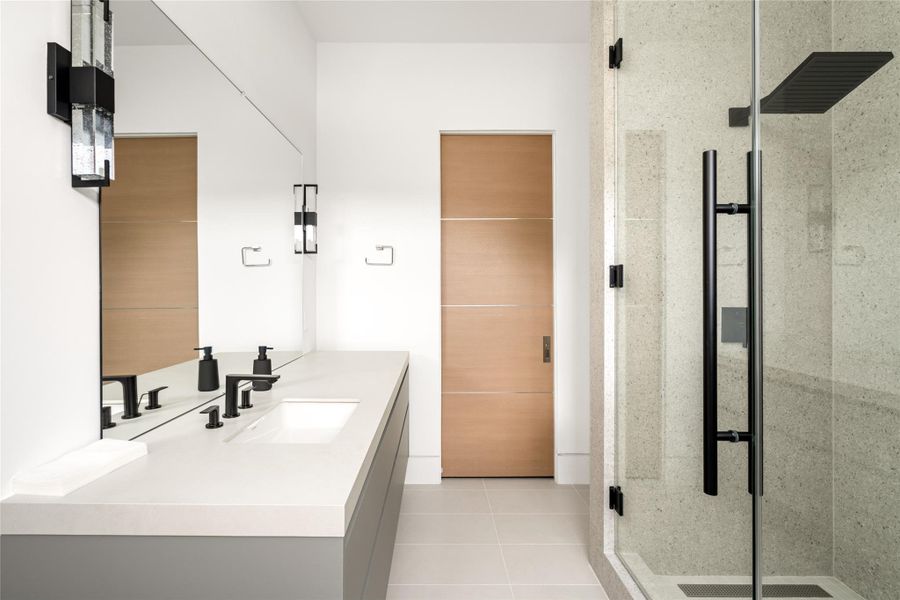 Secondary bathroom with modern finishes and glass-enclosed shower.