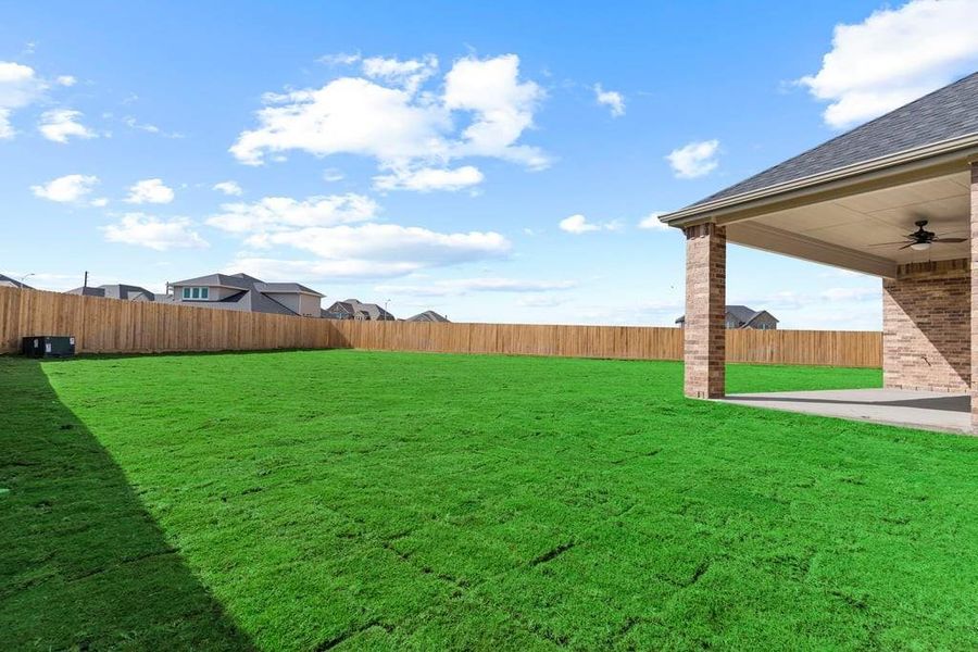 Large fenced-in backyard with a covered patio, perfect for outdoor entertaining. Large fenced-in backyard with a covered patio, perfect for outdoor entertaining.