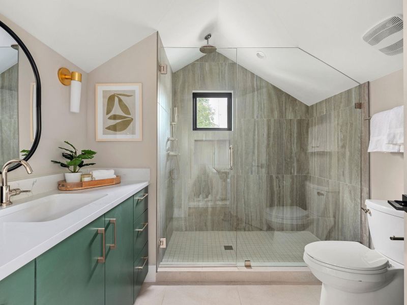 Bathroom featuring vaulted ceiling, vanity, a shower stall, and light tile patterned flooring Bathroom featuring vaulted ceiling, vanity, a shower stall, and light tile patterned flooring