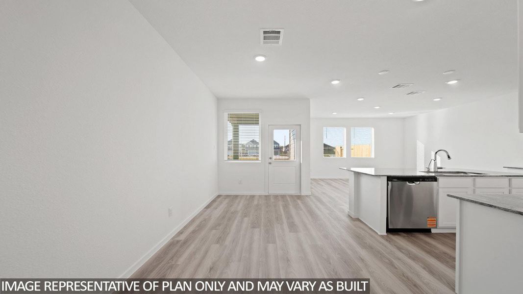 Expansive open-concept room featuring wood-finish flooring, recessed lighting, and bright white walls