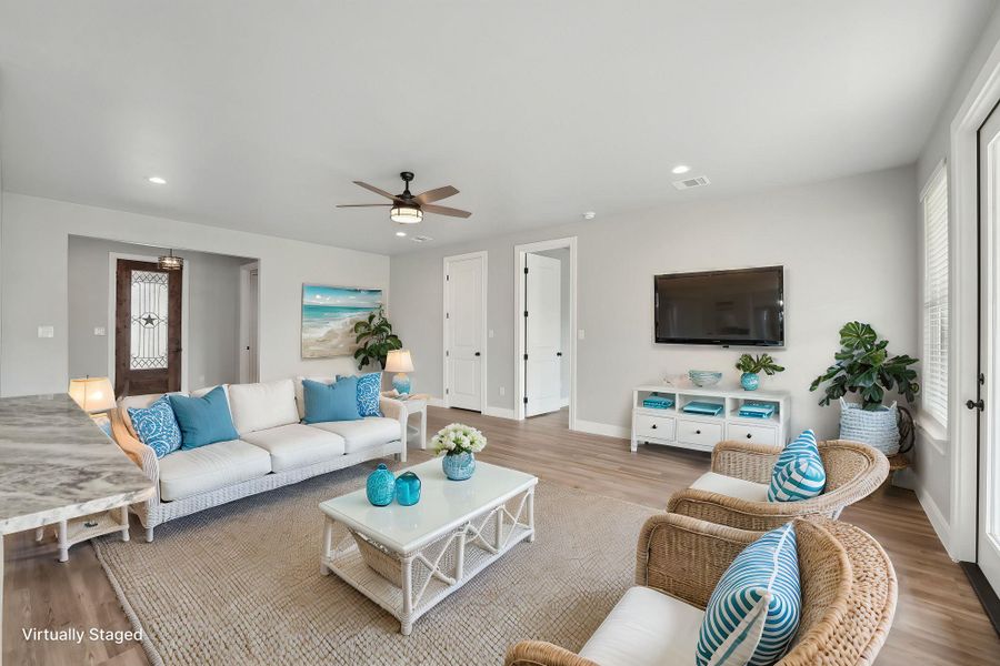 Virtually Staged Living area with visible vents, recessed lighting, ceiling fan, and wood finished floors