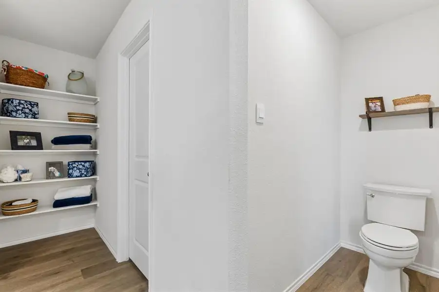 Bathroom featuring dark wood-type flooring and toilet Bathroom featuring dark wood-type flooring and toilet