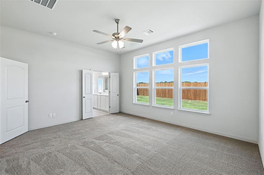 Unfurnished bedroom featuring carpet, ceiling fan, and connected bathroom Unfurnished bedroom featuring carpet, ceiling fan, and connected bathroom