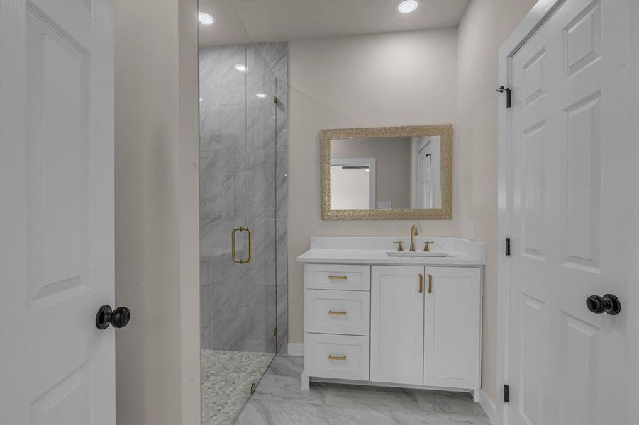 Bathroom with vanity and a shower with shower door