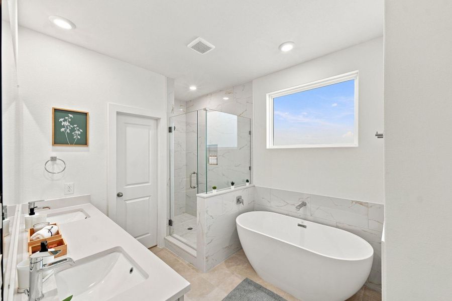 Beautiful primary bath combining a modern double vanity, soaking tub, separate shower, and contemporary finishes. Beautiful primary bath combining a modern double vanity, soaking tub, separate shower, and contemporary finishes.
