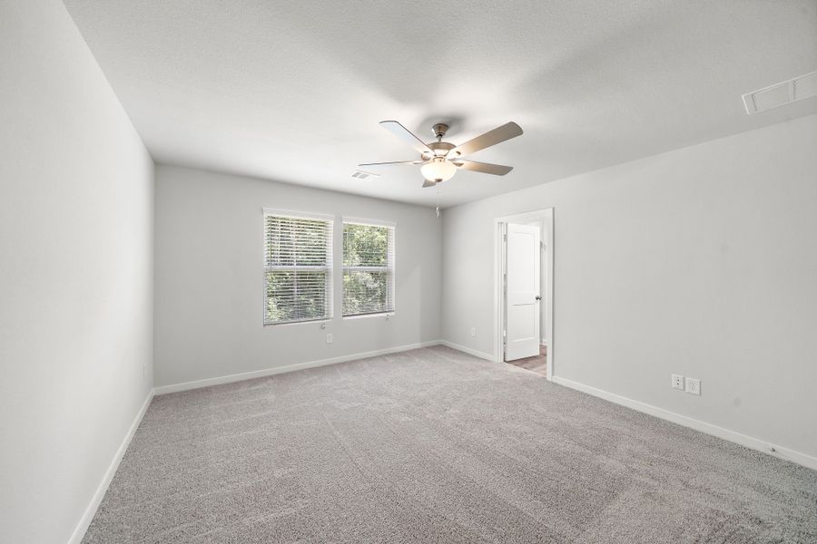 A room with a ceiling fan and a door.