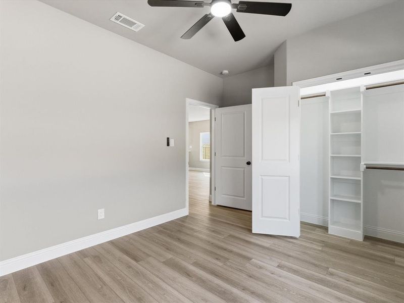 Unfurnished bedroom featuring light wood finished floors, ceiling fan, and a closet Unfurnished bedroom featuring light wood finished floors, ceiling fan, and a closet