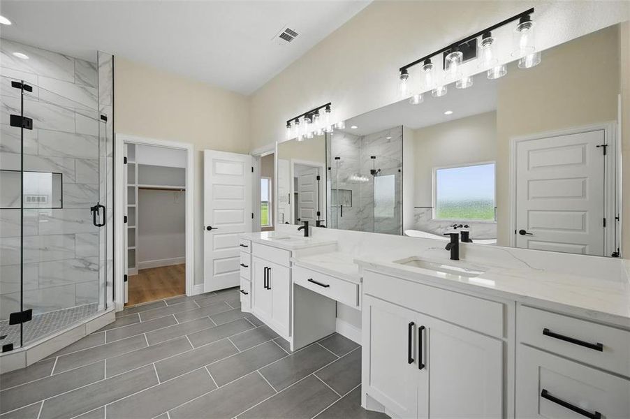 Full bath featuring a marble finish shower, two vanities, a walk in closet, and recessed lighting Full bath featuring a marble finish shower, two vanities, a walk in closet, and recessed lighting