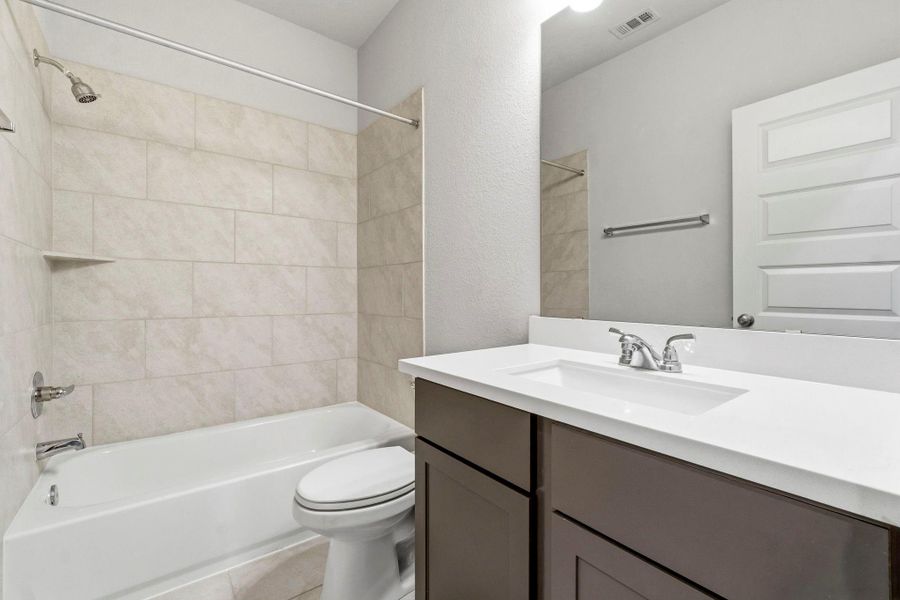 The guest ensuite bath features a convenient tub and shower combination.