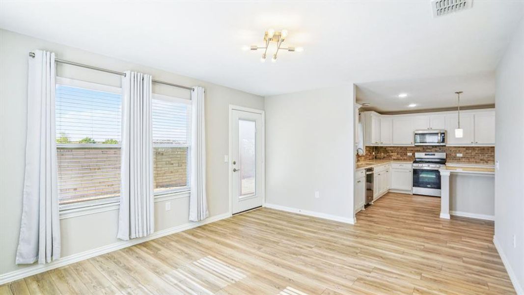 Kitchen with decorative light fixtures, appliances with stainless steel finishes, light wood-type flooring, tasteful backsplash, and recessed lighting Kitchen with decorative light fixtures, appliances with stainless steel finishes, light wood-type flooring, tasteful backsplash, and recessed lighting