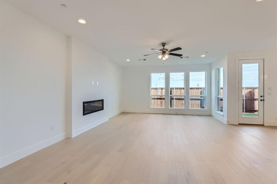 Unfurnished living room with light hardwood / wood-style floors and ceiling fan