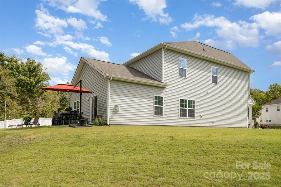 Large back yard with trees in the background