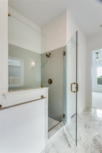 Bathroom featuring tile patterned floors, a shower with door, and ceiling fan