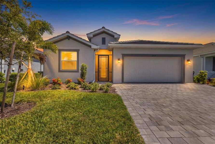 Front exterior of a new home in Palm Lake at Coco Bay, Englewood, FL, highlighting curb appeal (Image 2). Front exterior of a new home in Palm Lake at Coco Bay, Englewood, FL, highlighting curb appeal (Image 2).